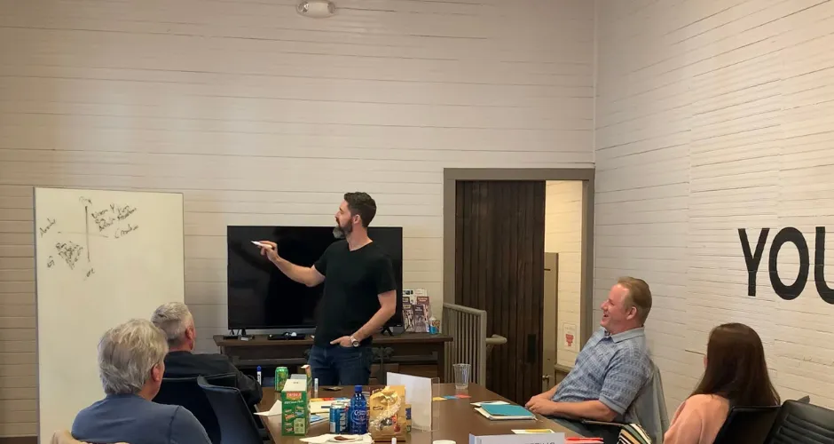 Justin Kier leading a session with a small group around a table